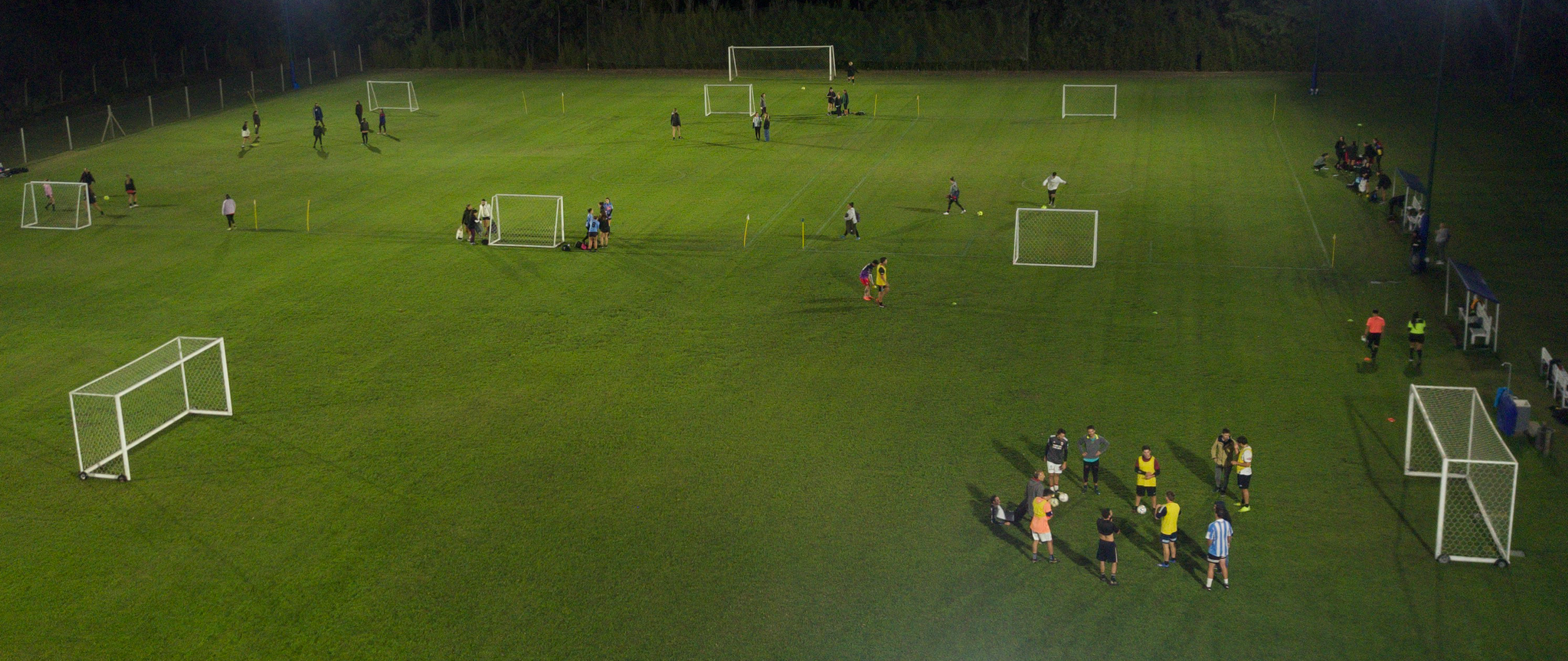Partido nocturno sobre césped natural bajo los reflectores en Oliden Fútbol
